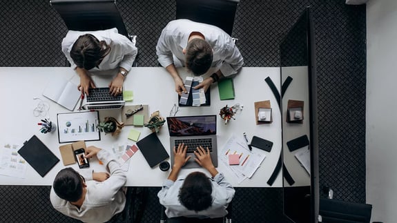 People sat at a business meeting with laptops