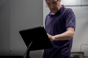 Machine Operator looking at tablet to log downtime